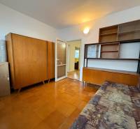 Pokoj v 3-pokojovém bytě s nábytkem ze dřeva a podlahou s dřevěným dekorem.