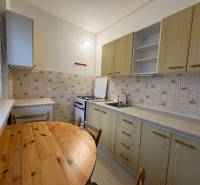 Kuchyně v 3-pokojovém bytě se stolem, dlažbou a útulným prostorem na vaření.