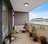 Balkon 2-pokojového bytu v Rovince na Slunečnicové ulici s pohodlným sezením a rostlinami.