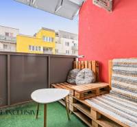 Balkon s paletovým nábytkem a stolkem, barevné budovy ve Vráblech, 2-pokojový byt.