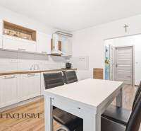 Kuchyně v 2-pokojovém bytě se světlými skříňkami a podlahou s dřevěným dekorem.