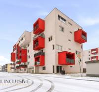 Exteriér bytového domu s červenými balkóny ve Vráblech, ideální pro 2-pokojový byt.