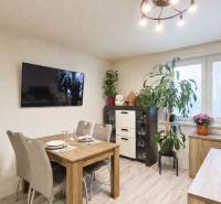 Jídelna v rodinném domě s televizorem, jídelním stolem a pokojovými rostlinami.