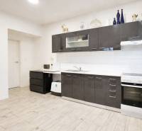 Kuchyně s tmavými skříňkami, podlaha s dřevěným dekorem, rodinný dům.