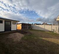 Dvůr v Ludanicích na Tiché u rodinného domu se zahradním domkem a trávníkem.