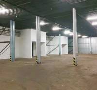 Uvnitř skladu jsou ocelové nosníky a betonová podlaha.