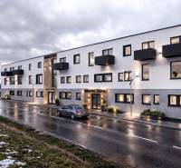 Budova na Nádražní ulici v Šenkvicích, sklady a haly, s večerním osvětlením.