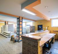 Interiéry skladů a hal s vstupní recepcí, regály a osvětlením.