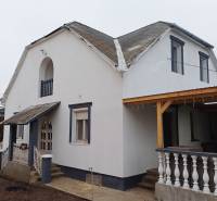 Rodinný dům ve Vizsoly se světlou fasádou a šikmou střechou.