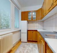 Kuchyně s podlahou s dřevěným dekorem a dřevěným nábytkem ve 4pokojovém bytě.