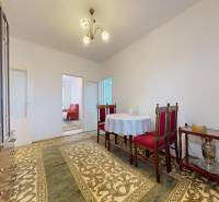 Jídelna ve 4-pokojovém bytě s koberci a zdobeným nábytkem.