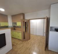 Interiér 2-pokojového bytu s podlahou s dřevěným dekorem a světlým nábytkem.