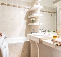 Koupelna s rohy v 3-pokojovém bytě, se sprchou, umyvadlem a pračkou.