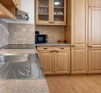 Kuchyně v 3-pokojovém bytě s dřevěným dekorem a moderním vybavením.