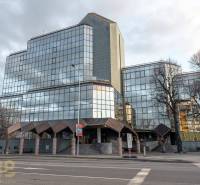 Prosklená budova kanceláří ve městě Poprad s minimalistickým designem a městským okolím.