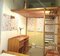 Dřevěný nábytek v útulném pokoji s patrovou částí ve 3-pokojovém bytě.