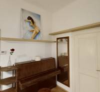 Interiér 3-pokojového bytu se zrcadlem, pianem a obrazem nad ním.