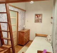 Pokoj se schody, dřevěným stropem, nábytkem a podlahou s dřevěným dekorem.