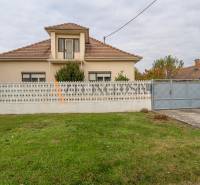 Rodinný dům ve Velkých Dvornících s plotem a udržovanou zahradou.