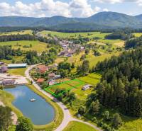 Letecký pohled na pozemky - bydlení v Ďurďovém, Považská Bystrica obklopené lesy a jezerem.