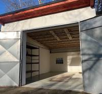 Otevřená garáž na Agátové v Bratislavě - Dúbravce s jednoduchým interiérem a regálem.