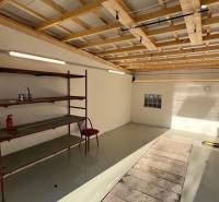 Interiér garáže s podlahou s dřevěným dekorem a regálem v Bratislavě na Agátové ulici.