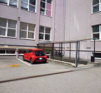 Parkoviště na Masarykově ulici v Prešově s cyklistickým stojanem u kanceláří.