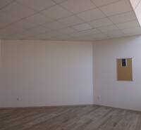 Místnost s podlahou s dřevěným dekorem a korkovou nástěnkou v kanceláři.