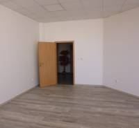 Kanceláře s podlahou s dřevěným dekorem a otevřenými dveřmi.