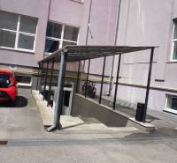 Budova kanceláří na Masarykově ulici v Prešově s přístřeškem a parkovištěm.