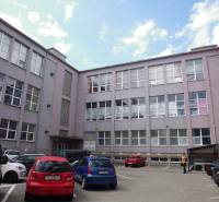 Budova s kancelářemi na Masarykově ulici v Prešově, před kterou jsou zaparkovaná auta.