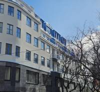 Budova v Bratislavě - Starém Městě na Poštové ulici se stromy v popředí.