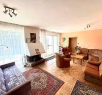 Obývací pokoj s krbem a koženou sedací soupravou v rodinném domě.