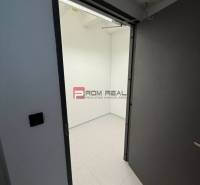 Otevřené dveře vedoucí do prázdné místnosti s bílými stěnami v kancelářích.