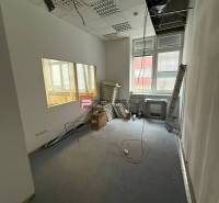 Kanceláře s pokládkou koberce, probíhající rekonstrukce, místnost s osvětlením a okny.