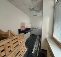 Kanceláře s podlahou z tmavých dlaždic, paletami a skříňkami, ideálně na Hřbitovní.