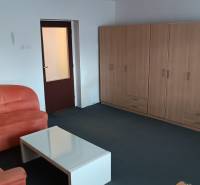 Obývací pokoj v rodinném domě s pohovkou, stolkem a skříní na míru.