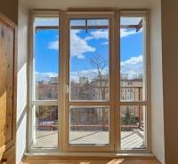 Pokoj s vestavěnou skříní a velkým oknem s výhledem na balkon.