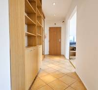 Chodba v 2-pokojovém bytě s vestavěnou skříní a světlou dlažbou.