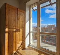 Slunný interiér 2pokojového bytu s podlahou s dřevěným dekorem a dřevěnou skříní.