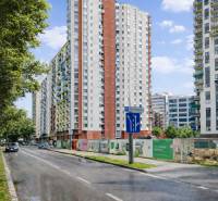 Výškové bytové domy na Jégého ulici v Bratislavě - Ružinově, vedle cesty s auty.