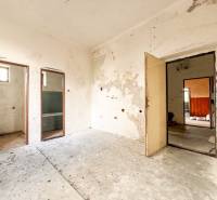 V rodinném domě je starý pokoj s opotřebovanými stěnami a odkrytými prostory.