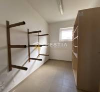 Úložný prostor s vertikálními kovovými regály a policí ve skladech a halách.