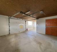 Sklady a haly s betonovou podlahou, dřevěným stropem a velkými garážovými vraty.