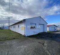 Sklady a haly v Rybkách s travnatým okolím pod oblačnou oblohou.