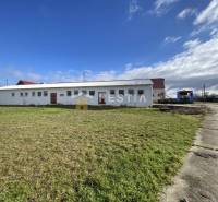 Sklady a haly v Rybkách obklopené zelenou plochou a betonovou cestou.