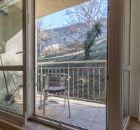 Balkon 3pokojového bytu se dvěma kovovými židlemi, vedoucí do zahrady.