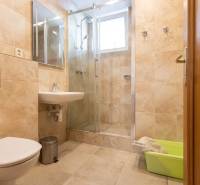 Koupelna v 3-pokojovém bytě s keramickými obklady a sprchovým koutem.