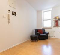 Interiér 3-pokojového bytu s křeslem, podlahou s dřevěným dekorem a obrazem na stěně.