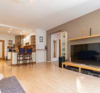 Obývací pokoj v 3-pokojovém bytě se zařízením a podlahou s dřevěným dekorem.